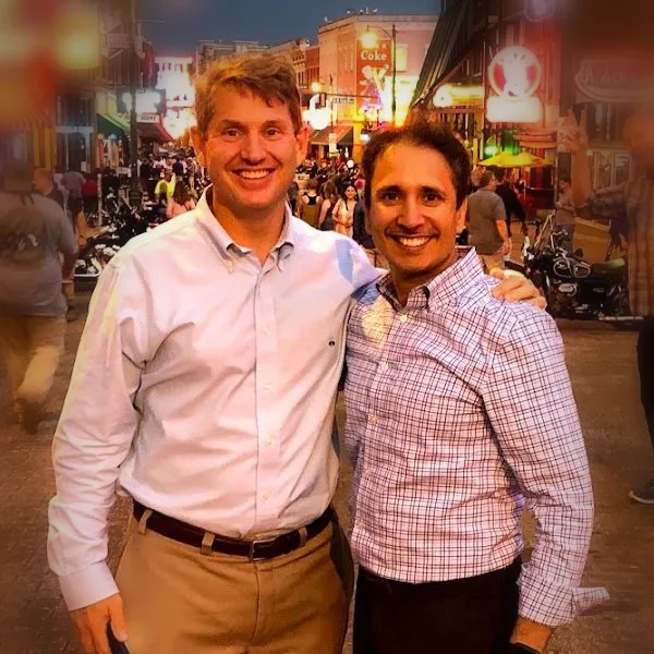 Tim Wood and Vikas Chopra on Beale Street in Memphis, smiling, arms around each other.
